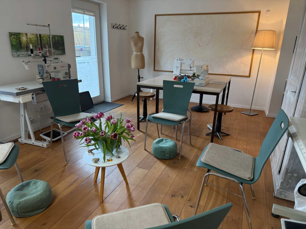 Stuhlkreis im Atelier mit Näharbeitsplatz im Hintergrund